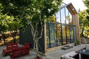 a house with a tree and two benches at Verde Motsameta in Motsameta