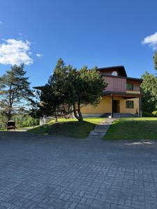 a house with a tree and a brick driveway at Cozy Urban Escape in Otepää