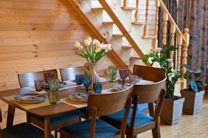 a dining room table with chairs and a wooden staircase at Verde Motsameta in Motsameta