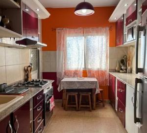 a small kitchen with a table and a window at appartement chaleureux in Oran