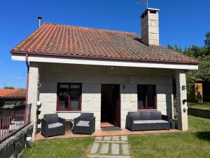 a house with two chairs and a roof at Casita Arnoia in Allariz