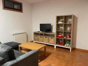 a living room with a couch and a tv at Casita Arnoia in Allariz