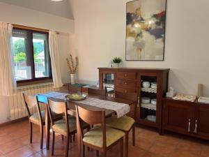 a dining room with a table and chairs and a cabinet at Casita Arnoia in Allariz