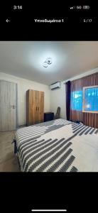 a bedroom with a bed with a black and white blanket at the grape house1 in Kalives Poligirou