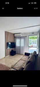 a living room with a couch and a flat screen tv at the grape house1 in Kalives Poligirou