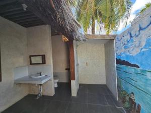 a bathroom with a sink and a toilet at Belar Reef Bungalows in Nembrala +49 photos