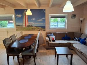 a living room with a table and a couch and a lighthouse at Domek nad morzem Jerzyk 506-385-791 in Stegna +9 photos