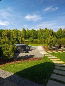 a park with picnic tables and a lake at Дивоніч guest house in Kyiv