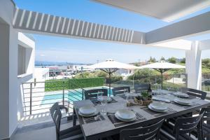 a table on a balcony with a view of the ocean at The Four Villas Hanioti by Luxlikehome in Hanioti