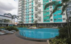 a large apartment building with a large swimming pool at Homey Studio Apartment in Mandaue in Mandaue City