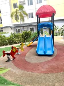 a playground with a blue slide in a park at Homey Studio Apartment in Mandaue in Mandaue City