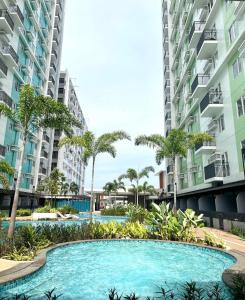 a swimming pool in the middle of two tall buildings at Homey Studio Apartment in Mandaue in Mandaue City