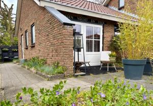 a brick house with a window and a chair outside at B&B Tussen Vecht en Veer in Hardenberg