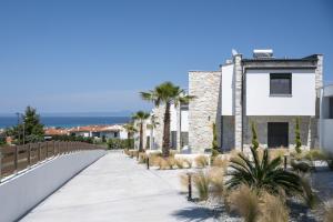 a walkway in front of a building with palm trees at The Four Villas Hanioti by Luxlikehome in Hanioti