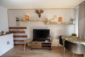 a living room with a television and a table at Beau studio Pra loup 1500 in Pra-Loup