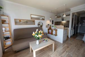 a living room with a couch and a table with flowers at Beau studio Pra loup 1500 in Pra-Loup