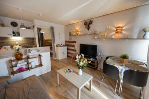 a living room with a table and a couch at Beau studio Pra loup 1500 in Pra-Loup +16 photos