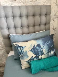 a pile of pillows sitting on a bed at Pebble Moon Holiday Flat in Strand