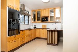 a kitchen with wooden cabinets and a sink at 157 on North-Sandton in Johannesburg