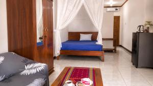 a bedroom with a bed and a couch and a table at Ocha Bajo Homestay in Komodo Labuan Bajo Airport