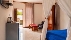 a bedroom with a bed and a table in a room at Ocha Bajo Homestay in Komodo Labuan Bajo Airport