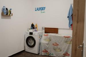 a laundry room with a table and a washing machine at Backpacker Hostel Kruje in Krujë