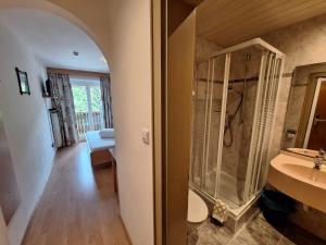 a bathroom with a walk in shower next to a sink at Hotel Pörnbacher in Valdaora +61 photos