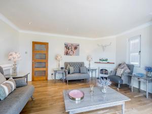 a living room with a couch and a table at Duck Bay Cottage 2 - Uk43935 in Balloch