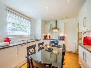 a kitchen with a table and chairs in a kitchen at Duck Bay Cottage 2 - Uk43935 in Balloch