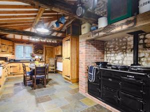a kitchen with a black stove and a table at Honey Pots in Foulden +16 photos