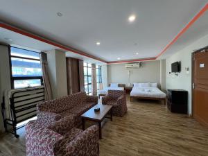a hotel room with a couch and a bed at Hotel Majesty Katari in Tribeni Ghāt