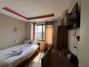 a bedroom with a large bed and a television at Hotel Majesty Katari in Tribeni Ghāt