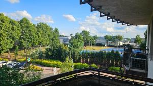 a balcony view of a park with a parking lot at Płock City Center Apartment in Płock