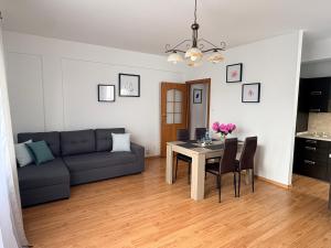 a living room with a table and a couch at Płock City Center Apartment in Płock