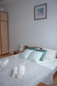 a white bed with two rolled towels on it at Płock City Center Apartment in Płock +17 photos