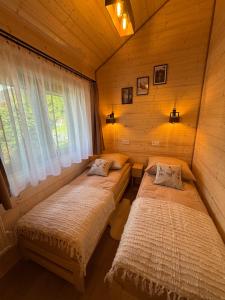 two beds in a room with a window at Las Się Żyje in Lutowiska