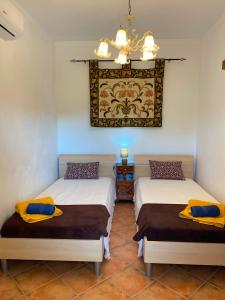 two beds in a room with yellow pillows on them at Casa dos Avós in São Brás de Alportel