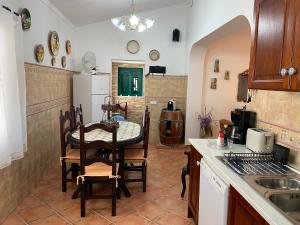 a kitchen with a table and chairs in a room at Casa dos Avós in São Brás de Alportel