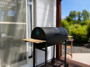 a bbq grill on a stand next to a window at Biwa 広々テラス bbq 無料駐車場 湖まで徒歩3分 in Takashima