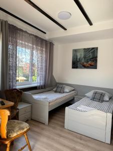 a bedroom with two beds and a window at Pokoje pod winogronami in Płoty