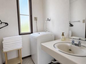 a white bathroom with a sink and a washing machine at Biwa 広々テラス bbq 無料駐車場 湖まで徒歩3分 in Takashima +27 photos
