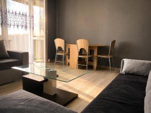 a living room with a glass table and chairs at BAIO Apart Sapphire in Libiąż