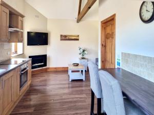 a kitchen with a table and chairs and a clock on the wall at Westfield Courtyard - Uk50704 in Garton