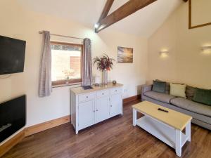 a living room with a couch and a tv at Westfield Courtyard - Uk50704 in Garton