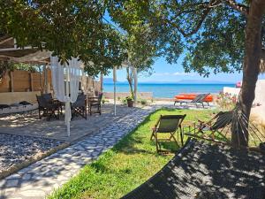 a patio with a table and chairs on the beach at Home Maro in Lefkimmi