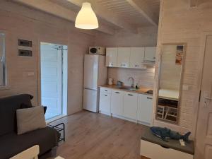 a small kitchen with a couch and a refrigerator at Domek nad morzem 79 in Stegna