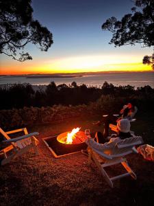 a group of people sitting in chairs around a fire at Aqua Straddies Best View Bay, Brissy & Beyond in Dunwich
