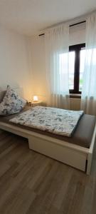 a large bed in a bedroom with a window at Stilvolle Wohnung in Waldbrunn in Waldbrunn
