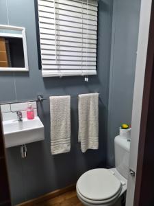 a bathroom with a toilet and a sink and towels at Stil Karoo in Montagu