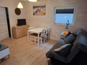 a living room with a couch and a table at Domek nad morzem 79 in Stegna